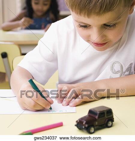 Close-up of a boy drawing on a sheet of paper View Large Photo Image Stock Photo - Close-up of a boy drawing on a sheet of paper. Fotosearch