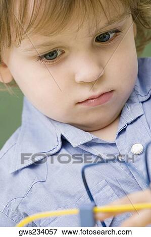 Stock Photo - Close-up of a boy playing with a toy. Fotosearch