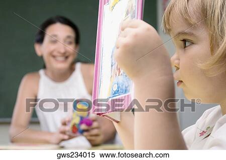 Close-up of a boy reading a book with his teacher sitting beside him View Large Photo Image Stock Photography - Close-up of a boy reading a book with his teacher sitting beside him. Fotosearch