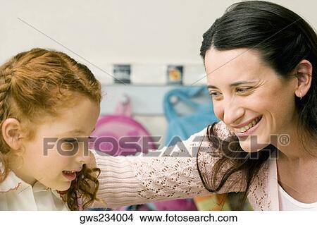 Female teacher teaching her student in a classroom View Large Photo Image Picture - Female teacher teaching her student in a classroom. Fotosearch