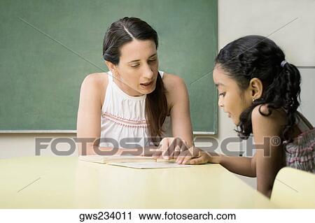 Female teacher teaching her student in a classroom View Large Photo Image Stock Image - Female teacher teaching her student in a classroom. Fotosearch