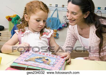 Female teacher teaching her student in a classroom View Large Photo Image Stock Image - Female teacher teaching her student in a classroom. Fotosearch