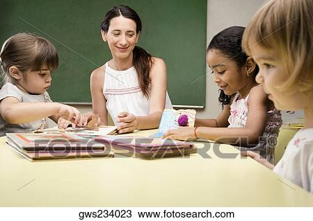 Female teacher teaching her students in a classroom View Large Photo Image Stock Image - Female teacher teaching her students in a classroom. Fotosearch