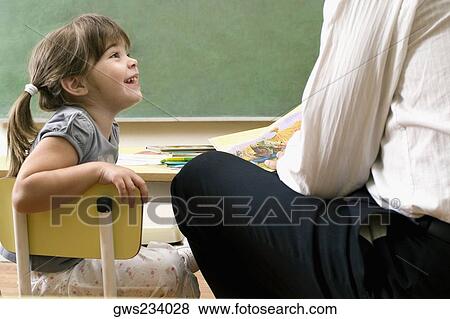 Male teacher teaching his student in a classroom View Large Photo Image Stock Photo - Male teacher teaching his student in a classroom. Fotosearch