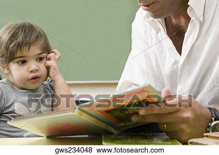 Male teacher teaching his student in a classroom View Large Photo Image Stock Photo - Male teacher teaching his student in a classroom. Fotosearch