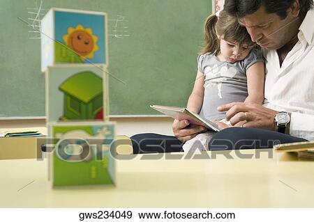 Male teacher teaching his student in a classroom View Large Photo Image Stock Photo - Male teacher teaching his student in a classroom. Fotosearch