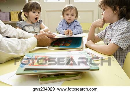 Male teacher teaching his students in a classroom View Large Photo Image Stock Photo - Male teacher teaching his students in a classroom. Fotosearch