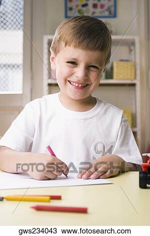 Portrait of a boy drawing on a sheet of paper and smiling View Large Photo Image Stock Image - Portrait of a boy drawing on a sheet of paper and smiling. Fotosearch