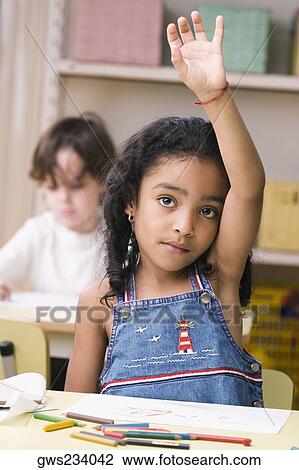 Portrait of a girl raising her hand in a classroom View Large Photo Image Stock Image - Portrait of a girl raising her hand in a classroom. Fotosearch