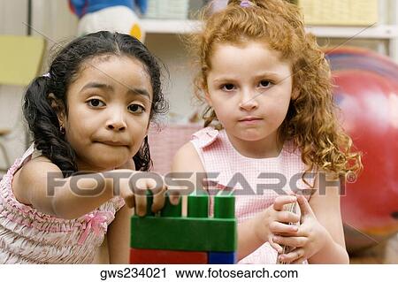 Portrait of two girls playing with plastic blocks View Large Photo Image Stock Image - Portrait of two girls playing with plastic blocks. Fotosearch
