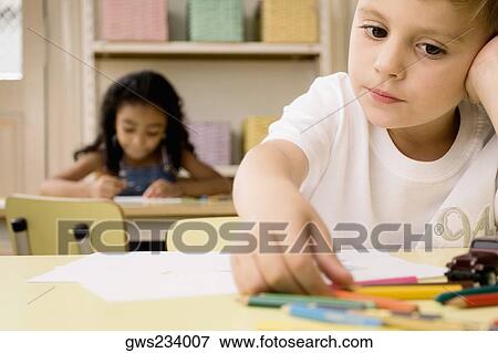 School children drawing on sheets of paper in a classroom View Large Photo Image Stock Photo - School children drawing on sheets of paper in a classroom. Fotosearch