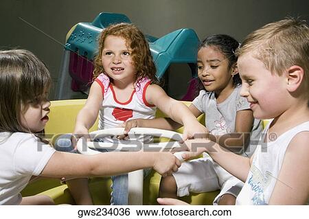 Three girls and a boy in a toy car View Large Photo Image Stock Photograph - Three girls and a boy in a toy car. Fotosearch
