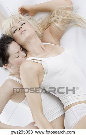 High angle view of a female homosexual couple lying on the bed View Large Photo Image Stock Image - High angle view of a female homosexual couple lying on the bed. Fotosearch