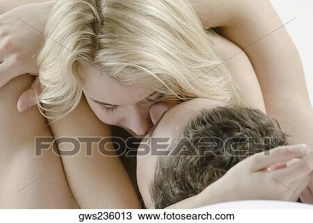 Stock Image - Close-up of a young couple romancing on the bed. Fotosearch