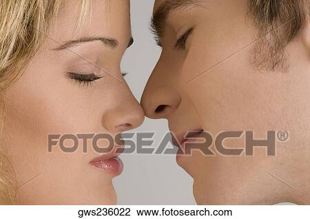 Close-up of a young couple romancing View Large Photo Image Stock Image - Close-up of a young couple romancing. Fotosearch