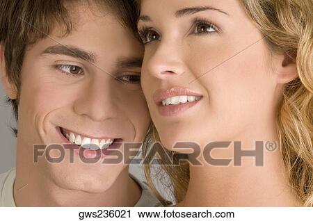 Close-up of a young couple smiling View Large Photo Image Stock Image - Close-up of a young couple smiling. Fotosearch