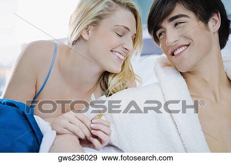 Close-up of a young couple smiling View Large Photo Image Stock Photo - Close-up of a young couple smiling. Fotosearch