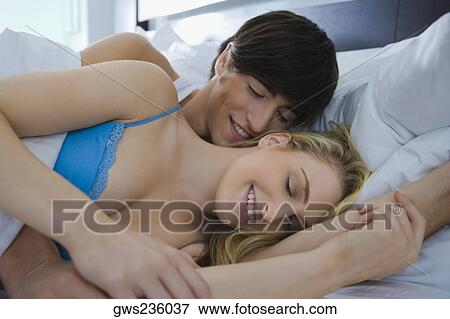 Young couple romancing on the bed View Large Photo Image Stock Photo - Young couple romancing on the bed. Fotosearch