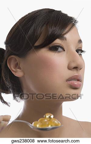 Close-up of a young woman holding a spoon of pills View Large Photo Image Stock Photo - Close-up of a young woman holding a spoon of pills. Fotosearch
