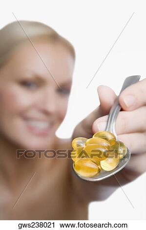Close-up of a young woman showing vitamin pills in a spoon View Large Photo Image Stock Image - Close-up of a young woman showing vitamin pills in a spoon. Fotosearch