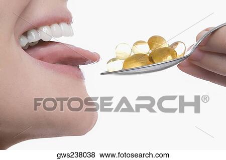 Close-up of a young woman taking a spoonful of pills View Large Photo Image Stock Photo - Close-up of a young woman taking a spoonful of pills. Fotosearch