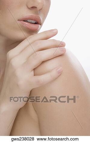 Stock Photo - Close-up of a young woman touching her shoulder. Fotosearch