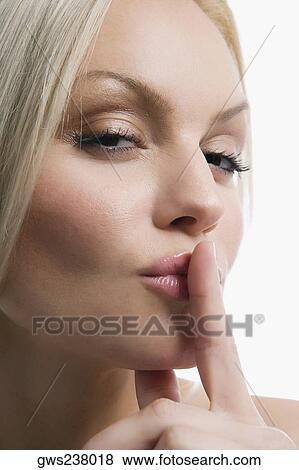 Portrait of a young woman with her finger on her lips View Large Photo Image Stock Photo - Portrait of a young woman with her finger on her lips. Fotosearch