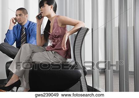 Businessman and a businesswoman talking on mobile phones View Large Photo Image Stock Photo - Businessman and a businesswoman talking on mobile phones. Fotosearch