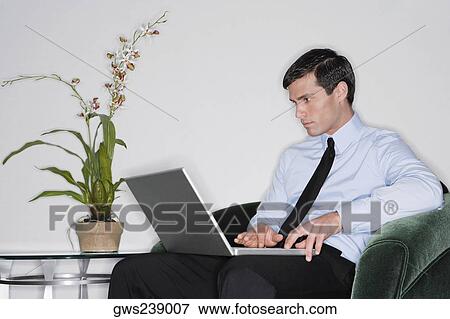 Businessman using a laptop View Large Photo Image Stock Photo - Businessman using a laptop. Fotosearch