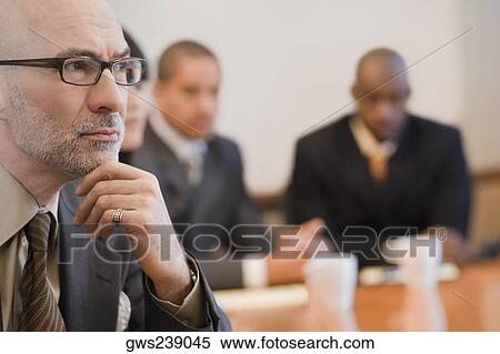 Close-up of a businessman with his colleagues in the background View Large Photo Image Stock Photography - Close-up of a businessman with his colleagues in the background. Fotosearch