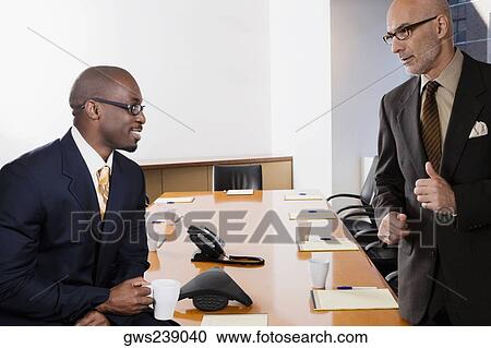 Two businessmen discussing in a conference room View Large Photo Image Stock Image - Two businessmen discussing in a conference room. Fotosearch