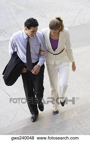 Businessman and a businesswoman moving up on steps with their arm in arm View Large Photo Image Stock Photo - Businessman and a businesswoman moving up on steps with their arm in arm. Fotosearch
