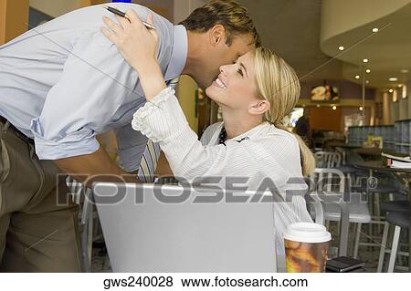 Businessman kissing a businesswoman in a restaurant View Large Photo Image Stock Photo - Businessman kissing a businesswoman in a restaurant. Fotosearch
