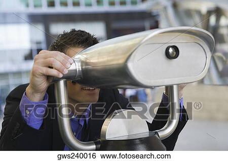 Stock Photograph - Businessman looking through a coin-operated binoculars. Fotosearch