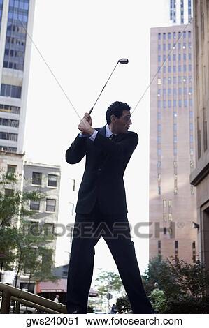Stock Image - Businessman playing golf. Fotosearch