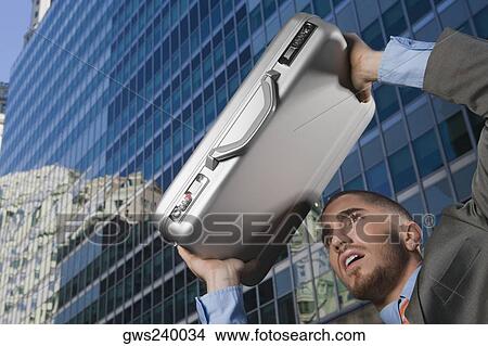 Businessman using his briefcase as a shade View Large Photo Image Picture - Businessman using his briefcase as a shade. Fotosearch
