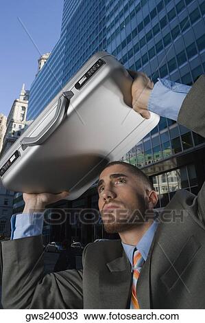 Businessman using his briefcase as a shade View Large Photo Image Stock Image - Businessman using his briefcase as a shade. Fotosearch