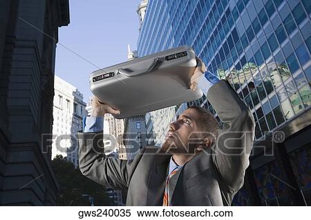 Businessman using his briefcase as a shade View Large Photo Image Stock Photography - Businessman using his briefcase as a shade. Fotosearch