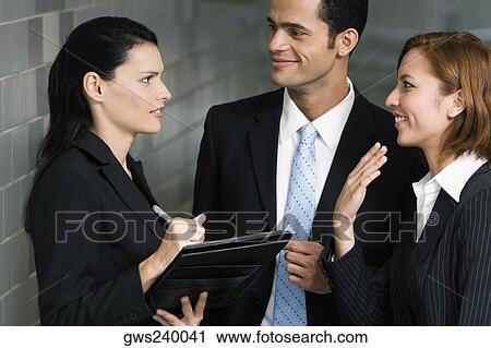 Close-up of a businessman and two businesswomen having a discussion View Large Photo Image Stock Image - Close-up of a businessman and two businesswomen having a discussion. Fotosearch