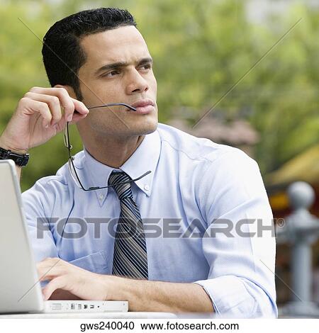Close-up of a businessman thinking while using a laptop View Large Photo Image Stock Image - Close-up of a businessman thinking while using a laptop. Fotosearch