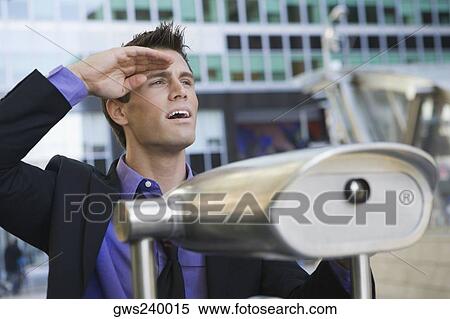 Close-up of a businessman with coin-operated binoculars in front of him View Large Photo Image Stock Photography - Close-up of a businessman with coin-operated binoculars in front of him. Fotosearch