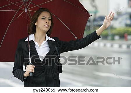 Close-up of a businesswoman hailing for a vehicle View Large Photo Image Stock Photography - Close-up of a businesswoman hailing for a vehicle. Fotosearch