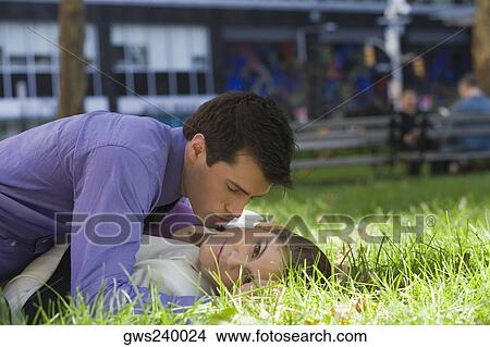 Picture - Young couple romancing in a park. Fotosearch