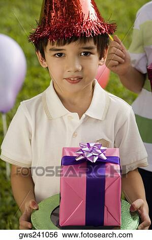 Boy holding a birthday present and smiling View Large Photo Image Stock Photograph - Boy holding a birthday present and smiling. Fotosearch