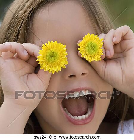 Close-up of a girl holding flowers over her eyes View Large Photo Image Stock Photography - Close-up of a girl holding flowers over her eyes. Fotosearch