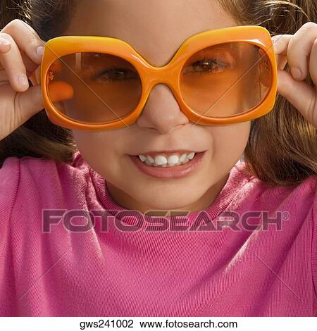 Close-up of a girl wearing an oversized sunglasses View Large Photo Image Stock Image - Close-up of a girl wearing an oversized sunglasses. Fotosearch