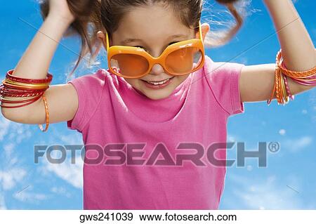 Close-up of a girl wearing sunglasses and smiling View Large Photo Image Stock Photo - Close-up of a girl wearing sunglasses and smiling. Fotosearch