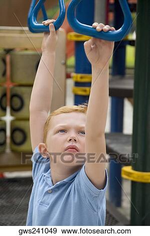 High angle view of a boy hanging on monkey bars View Large Photo Image Stock Photo - High angle view of a boy hanging on monkey bars. Fotosearch