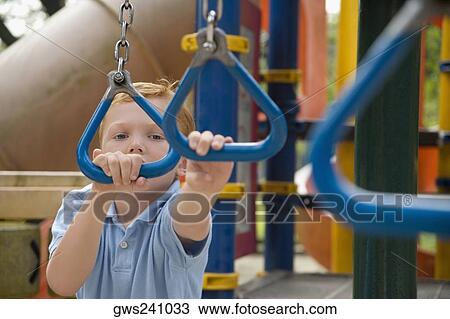 Portrait of a boy playing on monkey bars View Large Photo Image Stock Image - Portrait of a boy playing on monkey bars. Fotosearch