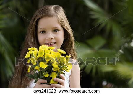 Portrait of a girl holding a bunch of flowers and smiling View Large Photo Image Stock Image - Portrait of a girl holding a bunch of flowers and smiling. Fotosearch